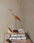 A Warm Nordic Beak Bird Tall Heron Oak figurine sitting on top of a table.