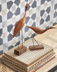 Two Warm Nordic Beak Bird Tall Heron Oak, designed in the Danish style, sit gracefully on top of books on a table.