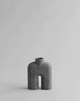 A small grey 101Cph Cobra Tall Mini Dark Grey 211034 vase sitting on a white surface.