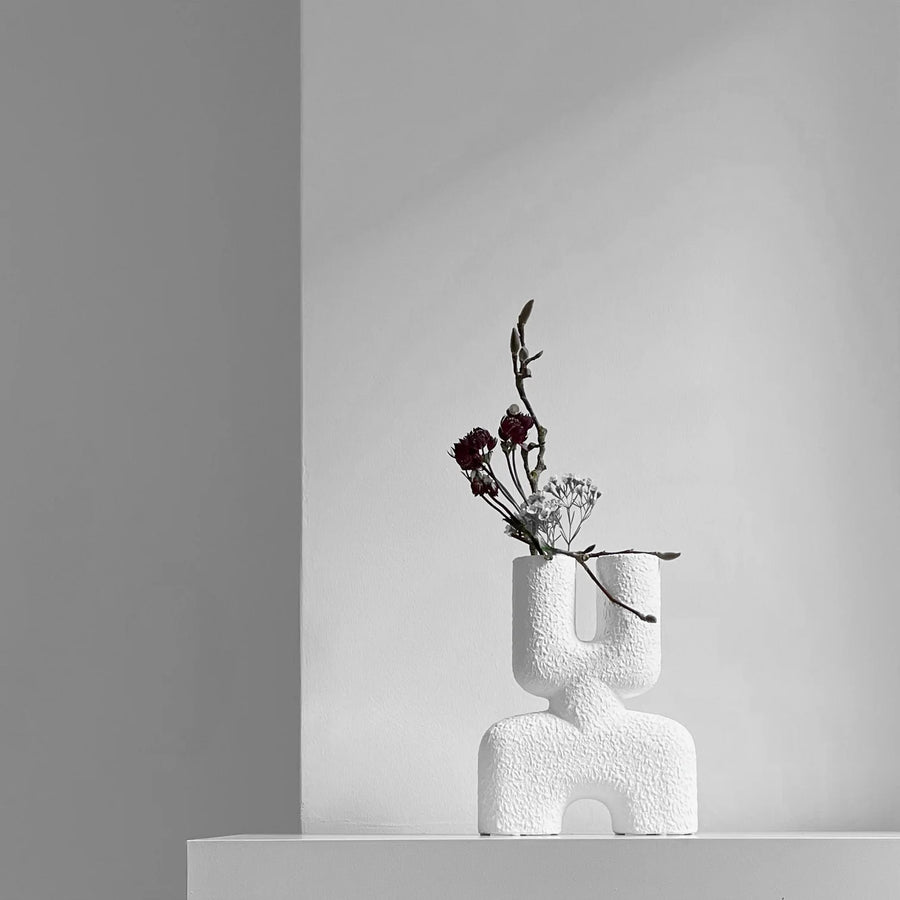 The Double Mini Bubble White Vase from 101cph with decorative flowers and foliage