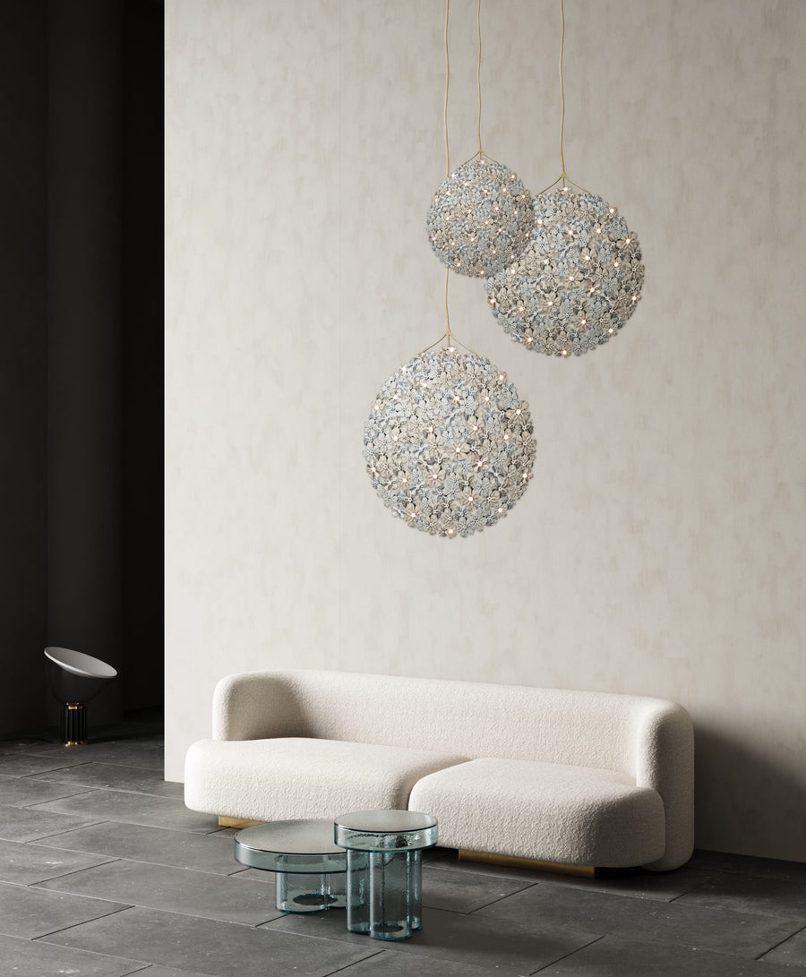 A living room with a Germanium LED Wall Paper with Swarovski couch by Meystyle, and three hanging balls providing ambient lighting.