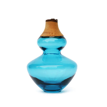 A curvy Utopia & Utility Inanna Stacking Vessel Aqua with a wooden handle.